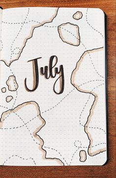 a notebook with the word july written in cursive writing on top of it