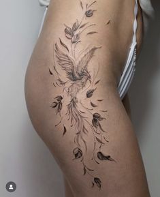 a woman's thigh with a bird and flowers tattoo on the side of her thighs