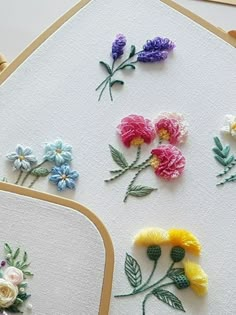 several different types of flowers are displayed on the table with white paper and gold trimmings