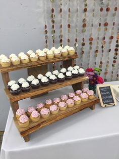 cupcakes are displayed on three tiered trays