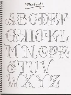 a handwritten alphabet is shown in black ink on a white paper with the word fancy written