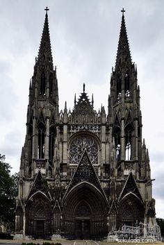 the large cathedral has many spires on it's sides and is surrounded by greenery