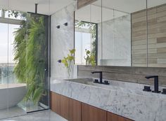 a large bathroom with marble counter tops and wooden cabinets, along with an oval bathtub