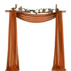 an orange drape with white flowers and greenery on the top, hanging from a wooden cross