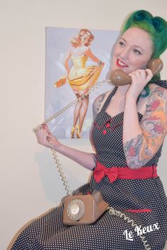 a woman with green hair is talking on the phone and holding a purse in her hand