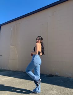 a woman leaning against a wall with her back to the camera