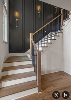 an empty room with black walls and white stairs