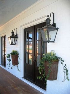 two hanging planters on the side of a house