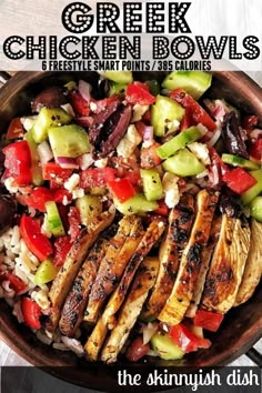 a bowl filled with chicken, cucumber and tomato salad on top of a wooden table