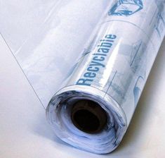 a roll of clear plastic wrapper sitting on top of a white tablecloth covered floor