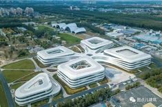 an aerial view of a large building with many windows on it's sides and lots of trees in the background