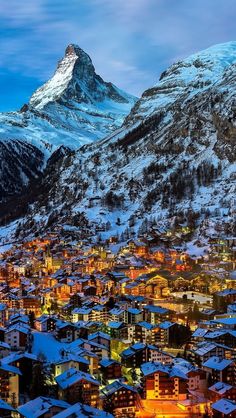 a snowy mountain with houses in the foreground