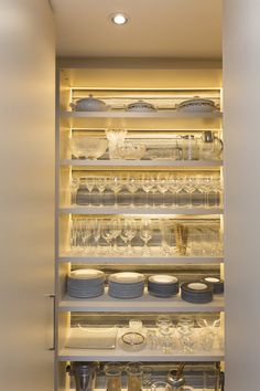 the shelves are filled with dishes and glasses