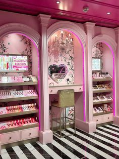 the inside of a store with pink walls and chandeliers