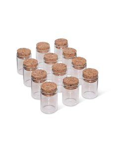 twelve glass jars with cork lids are lined up in a row on a white background