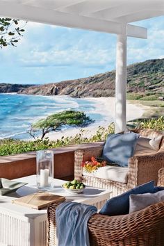 an outdoor living area with wicker furniture and ocean view