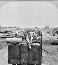 an old black and white photo of people in the back of a truck