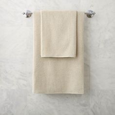 two white towels hanging on a towel rack