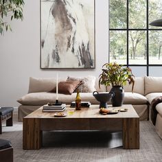 a living room filled with furniture and a large painting hanging on the wall above it