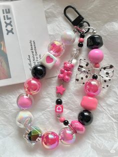 a close up of a necklace on a table with a book and keychain