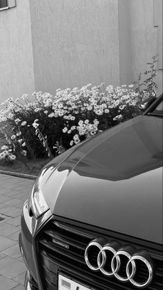 a black and white photo of an audi car parked on the side of the road