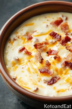 a brown bowl filled with cheese and bacon