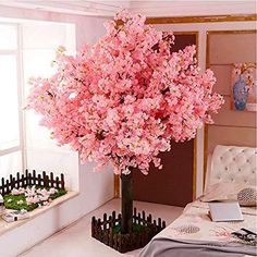 a bed room with a neatly made bed and a pink tree in the middle of it