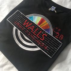 a black t - shirt with the words walls on it