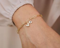 Experience the poetic harmony of love with our Personalized Love Duet Bracelet. Crafted from our delicate Gold-Plated paperclip chain, featuring 3 X 9mm links, this bracelet hosts two hearts—an enchanting fusion of one heart in white enamel and Gold-Plate and the other in 14 karat gold filled allure. Measuring about 1/4"x1/4" each, these hearts, with their distinct shapes, engage in a graceful choreography along the sophisticated paperclip chain. Customize the golden heart with a single initial, White Heart Bracelet For Everyday, White Heart Bracelet For Everyday Wear, Paperclip Bracelet With Extender As Gift, Golden Heart, Two Hearts, White Enamel, Paper Clip, Of Love, Gold Filled