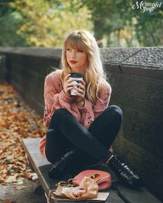 a woman sitting on a bench holding a camera