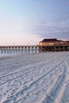 a long pier sitting on top of a sandy beach