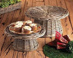 two wicker trays with cupcakes on them sitting on a wooden floor