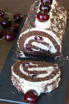 a chocolate roll with white frosting and cherries