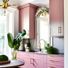 a kitchen with pink cabinets and green plants on the counter top, along with a gold faucet