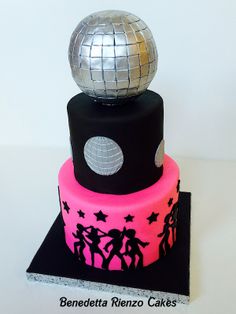 a three tiered cake decorated with disco ball and stars on the top, in pink and black