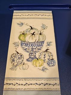 an embroidered dish towel with pumpkins and gourds in a bowl on it