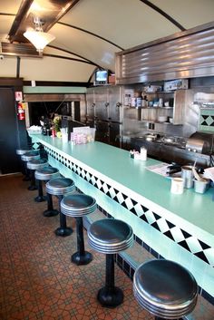 an empty restaurant with several stools at the counter