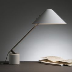 an open book sitting on top of a table next to a lamp