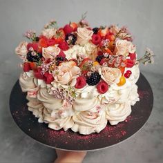 there is a cake with berries and flowers on it