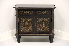 an ornate black and gold cabinet against a white wall