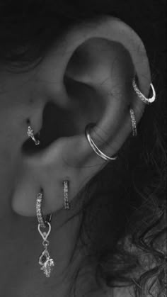 a woman's ear with three different types of piercings