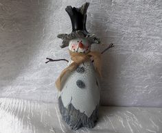 a snowman made out of an egg with a hat and scarf on it's head