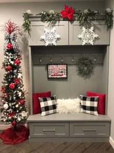 a bench with christmas decorations on it and a christmas tree in the corner next to it