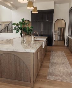 a large kitchen with marble counter tops and wooden cabinets