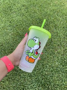 a hand holding a plastic cup with a cartoon character on it