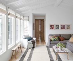 a living room filled with furniture and lots of windows