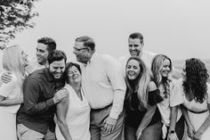 a group of people standing next to each other in front of a body of water