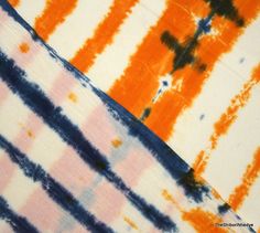 an orange and blue tie - dye pattern with black dots on it's edges