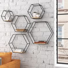 three hexagonal shelves on the wall above a couch in front of a window