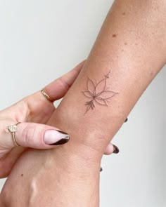 a woman's arm with a small tattoo on the left side of her wrist